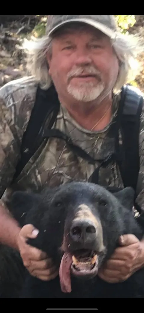Hunter holding a black bear's head