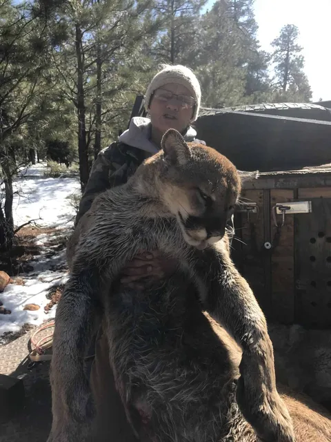 Hunter with a mountain lion beside the dog box