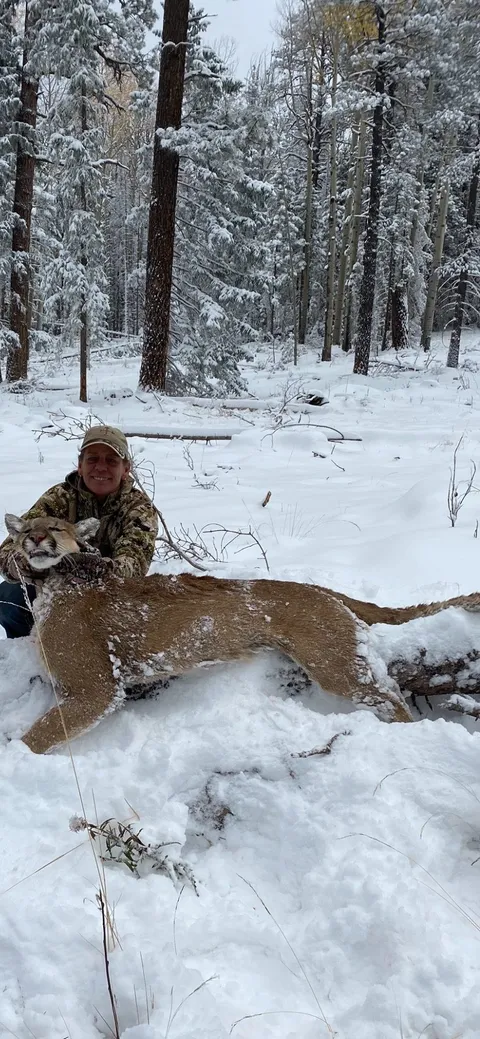 Hunter with a mountain lion in deep snow