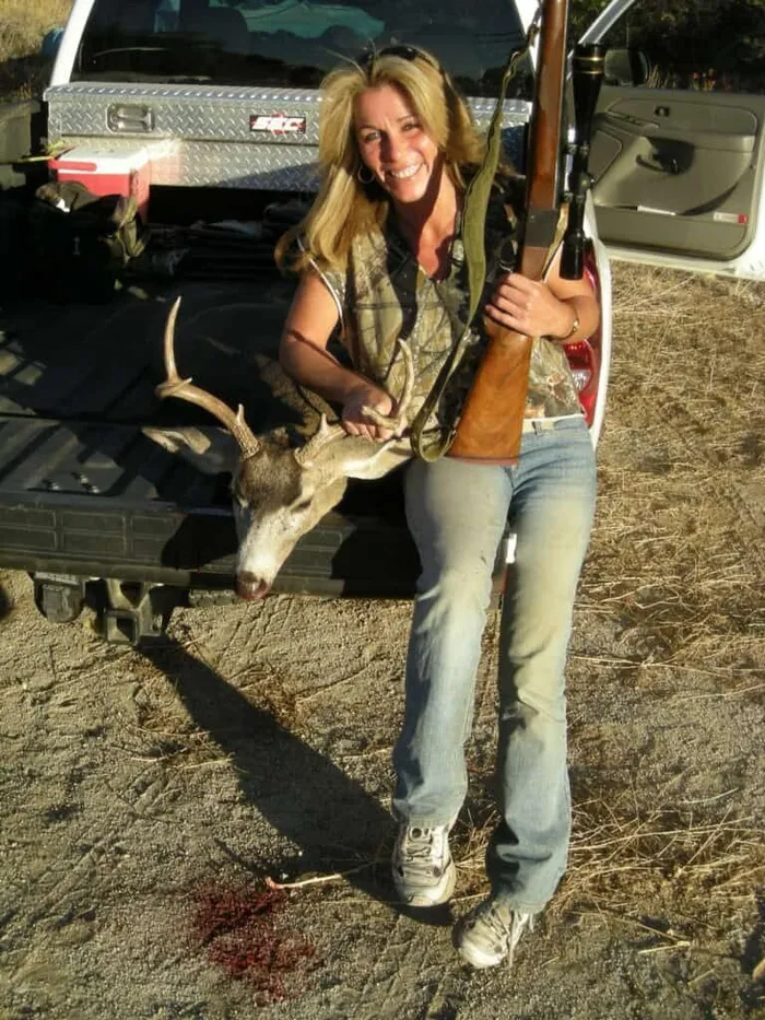 Hunter with a mule deer buck on a truck tailgate