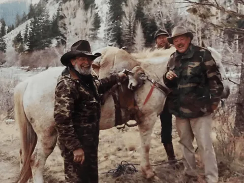 Vintage photo of hunters with a bighorn ram on a pack horse