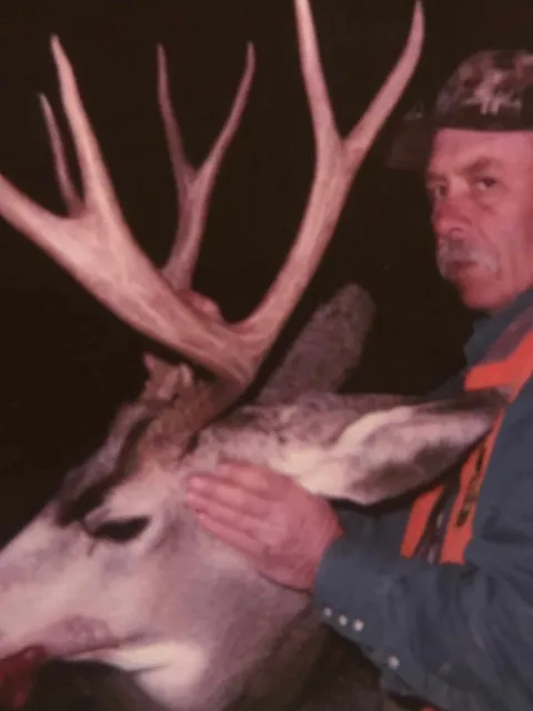 Vintage photo of a hunter with a mule deer buck